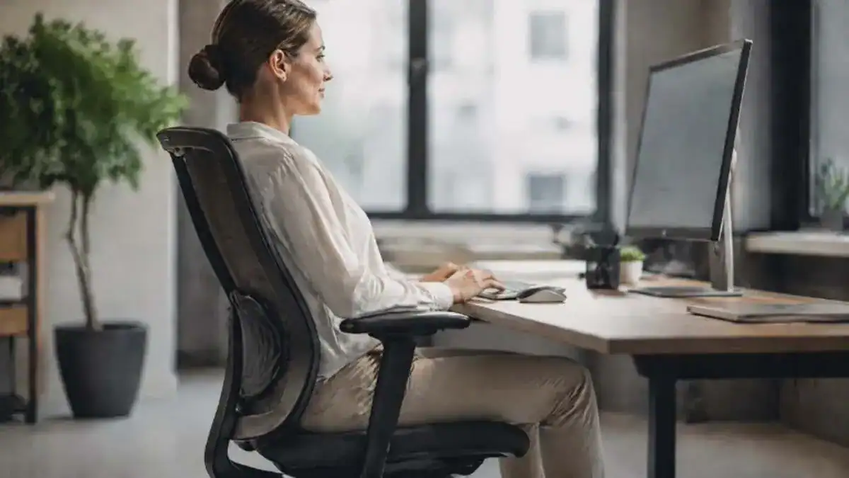 What is lumbar support shown by a person sitting with the lower back supported by an office chair
